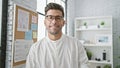 Confident young hispanic man, a smiling boss, enjoying success in the business world, standing relaxed in the office - a portrait Royalty Free Stock Photo