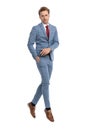 Confident young man in blue suit holding hand in pocket and jumping Royalty Free Stock Photo