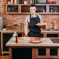 Confident young man with fresh baked pizza