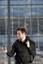 Confident young man reading text message on mobile phone Royalty Free Stock Photo