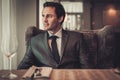 Confident young man sitting in restaurant waiting for somebody Royalty Free Stock Photo