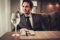 Confident young man sitting in restaurant waiting for somebody Royalty Free Stock Photo