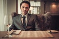 Confident young man sitting in restaurant waiting for somebody. Royalty Free Stock Photo