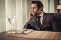 Confident young man sitting in restaurant waiting for somebody. Royalty Free Stock Photo