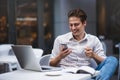 Confident young man in smart casual wear holding a cup and talking by smartphone. Royalty Free Stock Photo