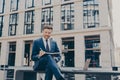 Confident young man in smart casual wear writing something in his notebook while sitting on bench Royalty Free Stock Photo