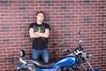 Confident Young Man Standing Behind his Motorbike Royalty Free Stock Photo