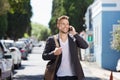 Confident young man walking outside with mobile phone Royalty Free Stock Photo