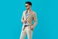 Confident young man wearing sunglasses and adjusting coat Royalty Free Stock Photo