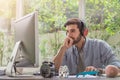 Confident young man working and concentrate on monitor while sitting at his working place in office Royalty Free Stock Photo