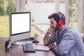 Young professional working on the computer and smiling while sitting at his working place in home office Royalty Free Stock Photo