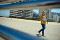 Confident business lady in casual attire, holding laptop and walking on the street against high rise building background Royalty Free Stock Photo