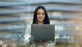 Confident young professional woman using a laptop, overlayed with dynamic financial charts Royalty Free Stock Photo