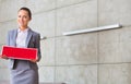 Portrait of confident young saleswoman holding sold placard while standing against wall in apartment