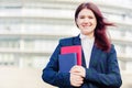 Confident young smiling student outdoors holding books Royalty Free Stock Photo