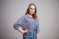 Confident young student girl wearing glasses and looking at the camera. Successful Redhead woman in a striped blouse and blue Royalty Free Stock Photo