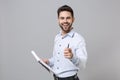 Confident young unshaven business man in light shirt isolated on grey background. Achievement career wealth business