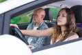 Confident young woman driving car with man in passenger seat Royalty Free Stock Photo