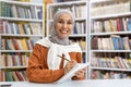 Confident young woman with hijab studying in library Royalty Free Stock Photo