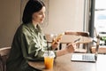 Confident Young Woman Holding Credit Card and Smartphone Making Online Shopping While Sitting at a Cafe Table on Terrace Royalty Free Stock Photo