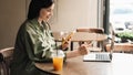 Confident Young Woman Holding Credit Card and Smartphone Making Online Shopping While Sitting at a Cafe Table on Terrace Royalty Free Stock Photo