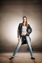 Confident young woman in jeans, top, jacket standing with serious look Royalty Free Stock Photo