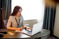 Young red-haired woman sitting at table and working on laptop Royalty Free Stock Photo