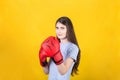 Confident young woman with red boxing gloves stands in fighting position. Portrait of strong and determined girl prepared for Royalty Free Stock Photo