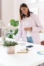 Confident young woman in smart casual wear smiling while standing near her working place Royalty Free Stock Photo