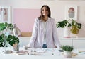 Confident young woman in smart casual wear smiling while standing near her working place Royalty Free Stock Photo