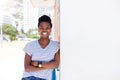 Confident young woman smiling against shite wall