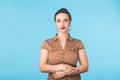 Confident young woman standing over blue background