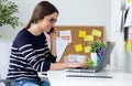 Confident young woman working in her office with laptop. Royalty Free Stock Photo