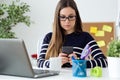 Confident young woman working in her office with mobile phone. Royalty Free Stock Photo