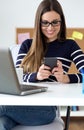 Confident young woman working in her office with mobile phone. Royalty Free Stock Photo