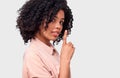 African American young woman dressed in pink shirt holding index finger on lips, asking to keep silence over white wall. Royalty Free Stock Photo