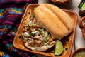 Confit pork sandwich called Torta de carnitas on white background. Mexican food