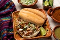 Confit pork sandwich called Torta de carnitas on white background. Mexican food