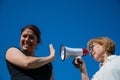 The conflict of generations. An emotional elderly woman shouting at her daughter in a megaphone. An elderly mother