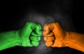 Conflict between India and Pakistan, male fists with flags painted on skin isolated on black background
