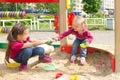 Conflict on the playground. Two kids fighting over a toy shovel in the sandbox Royalty Free Stock Photo