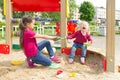 Conflict on the playground. Two sisters fighting over a toy shovel in the sandbox Royalty Free Stock Photo