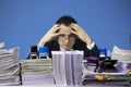 Confused accountant looking at camera surrounded by huge piles of documents Royalty Free Stock Photo