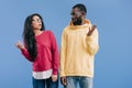 confused african american couple in eyeglasses looking at each other and doing dubium gesture