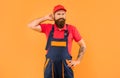 confused bearded deliveryman in work clothes on yellow background