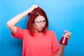 Confused beautiful nerd girl with a tube of red liquid in her ha Royalty Free Stock Photo