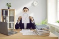 Confused business man worker sitting at the desk holding a sheet of paper with a question mark. Royalty Free Stock Photo