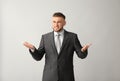 Confused businessman on grey background Royalty Free Stock Photo