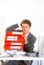 Confused businessman sitting at desk with folders Royalty Free Stock Photo