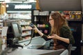 Confused cashier woman on workspace in supermarket Royalty Free Stock Photo